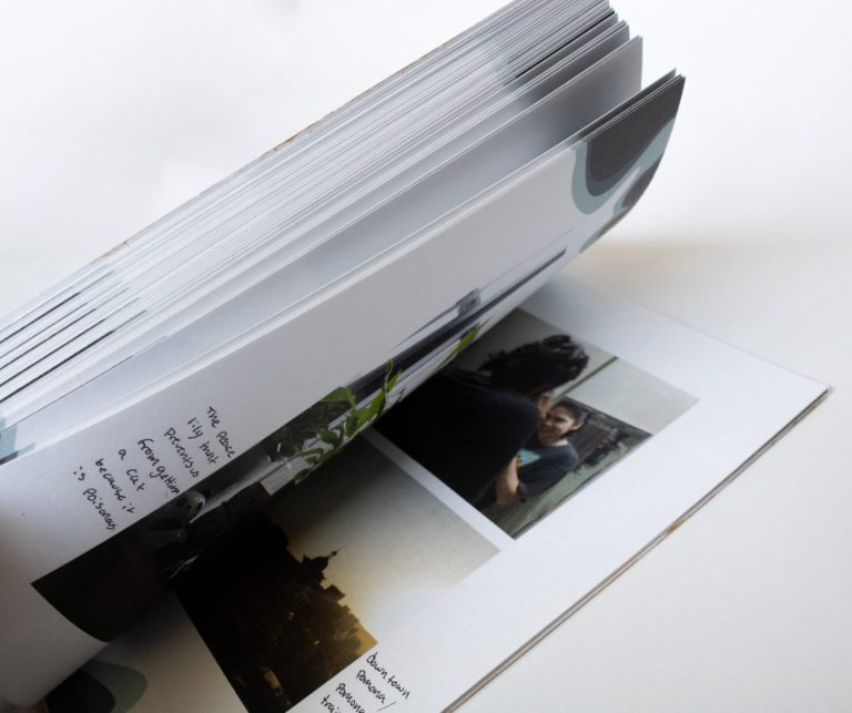 a book turning to a page of images with written text that is illegible 